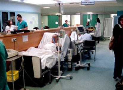 Dos pacientes en sus camas frente a un mostrador de urgencias del 12 de Octubre.
