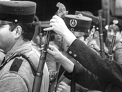 La empleada de una cafetería, Celeste Caeiro, coloca una flor en el arma de un militar durante la Revolución de los Claveles, 25 de abril de 1974.