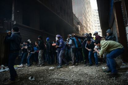 Los manifestantes lanzan piedras y se protegen de la policía durante una protesta este viernes en un barrio de El Cairo.
