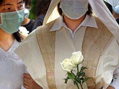 La viuda de un enfermero muerto por la neumonía en Hong Kong, en el entierro del marido.
/ AP