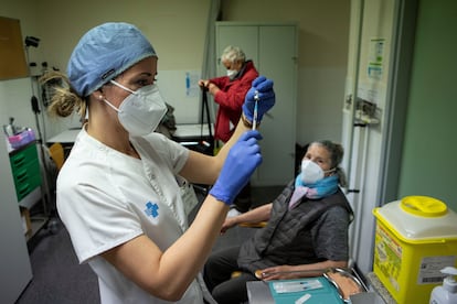 Uma enfermeira se prepara para injetar a primeira dose da vacina contra a covid-19 em uma idosa de Barcelona, em 3 de março.