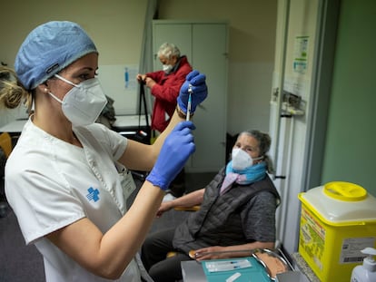 Uma enfermeira se prepara para injetar a primeira dose da vacina contra a covid-19 em uma idosa de Barcelona, em 3 de março.