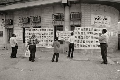 Un grupo de iraquíes contempla un mural que muestra restos de desaparecidos, en 2003 en Bagdad.