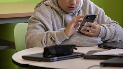 Un alumno de 2º de la ESO utiliza su telefono móvil durante un ejercicio en clase. 