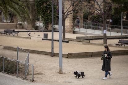 Una mujer pasea con su perro sin correa en el parque Joan Miró.