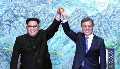 O presidente da Coreia do Norte, Kim Jong-un, e o da Coreia do Sul, Moon Jae-in, levantam os braços durante o encontro de sexta-feira