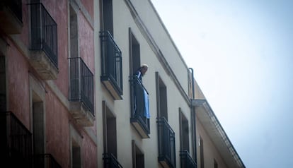 Un home al balcó del pis ocupat al carrer Unió, al Raval.