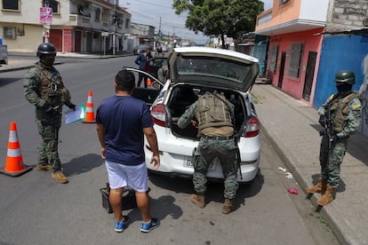 Soldados inspeccionan autos en un bloqueo vial en Guayaquil, Ecuador.