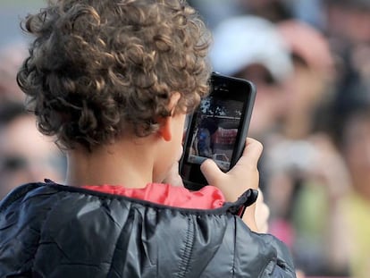 Un niño usa un teléfono móvil.