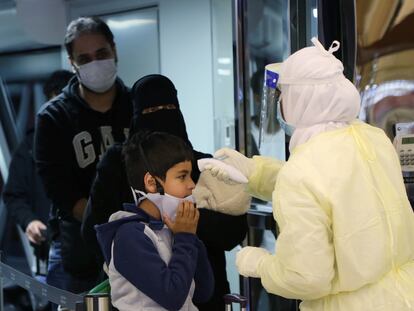 Funcionário de aeroporto na Arábia Saudita mede a temperatura de uma criança vinda da China, onde começou a circular o coronavírus.