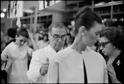 Cristóbal Balenciaga ajusta uno de sus modelos, en París en 1968.