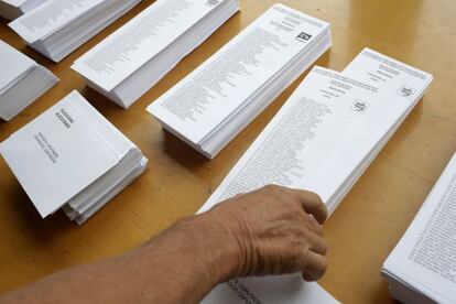 A voter picks up a ballot paper for the Junts Pel Si "Together for Yes" bloc in Barcelona.