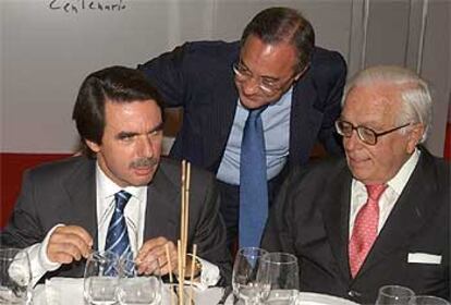 Aznar recibe el saludo de Florentino Pérez tras la conferencia en la que el presidente del Gobierno ha confirmado que va a ser abuelo.