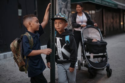 Kimberly Carchipulla, right, and her son 5-year-old Damien, center, wait for the bus on their way to school on Thursday, Sept. 7, 2023, in New York