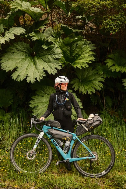 Una ciclista se protege de la lluvia, Across Andes, ruta Patagonia Chile en bici. 