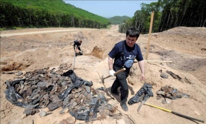 Investigadores en la fosa común hallada en Vladivostok.