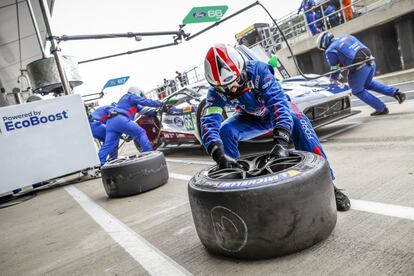Los mecánicos del equipo Ford Chip Ganassi cambian las ruedas al coche durante una parada.