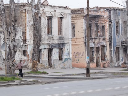 Una niña pasea junto a unos edificios destruidos en el centro de Mariupol