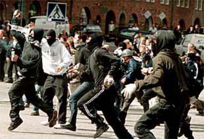 Un grupo de manifestantes apedrea a la policía sueca en el centro de Gotemburgo durante la primera jornada de la cumbre de la Unión Europea.