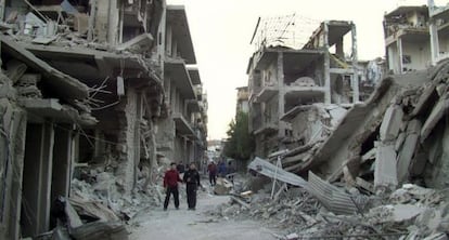 Un grupo de jóvenes en mitad de los escombros en Homs (Siria).