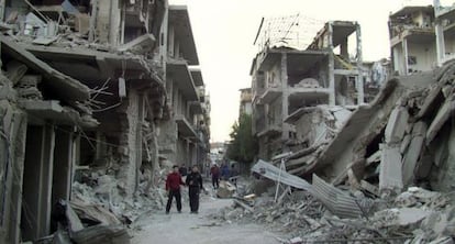 Un grupo de j&oacute;venes en mitad de los escombros en Homs (Siria). 