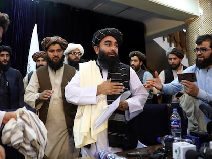 Zabihullah Mujahid (centro), portavoz de la insurgencia afgana, interviene en la primera rueda de prensa de los talibanes tras hacerse con el poder, celebrada este martes en Kabul.