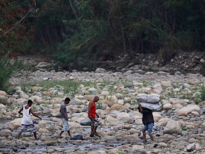 Un grupo de personas cruza el río Táchira, en las afueras de Cúcuta.