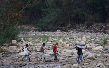 Un grupo de personas cruza el río Táchira, en las afueras de Cúcuta.