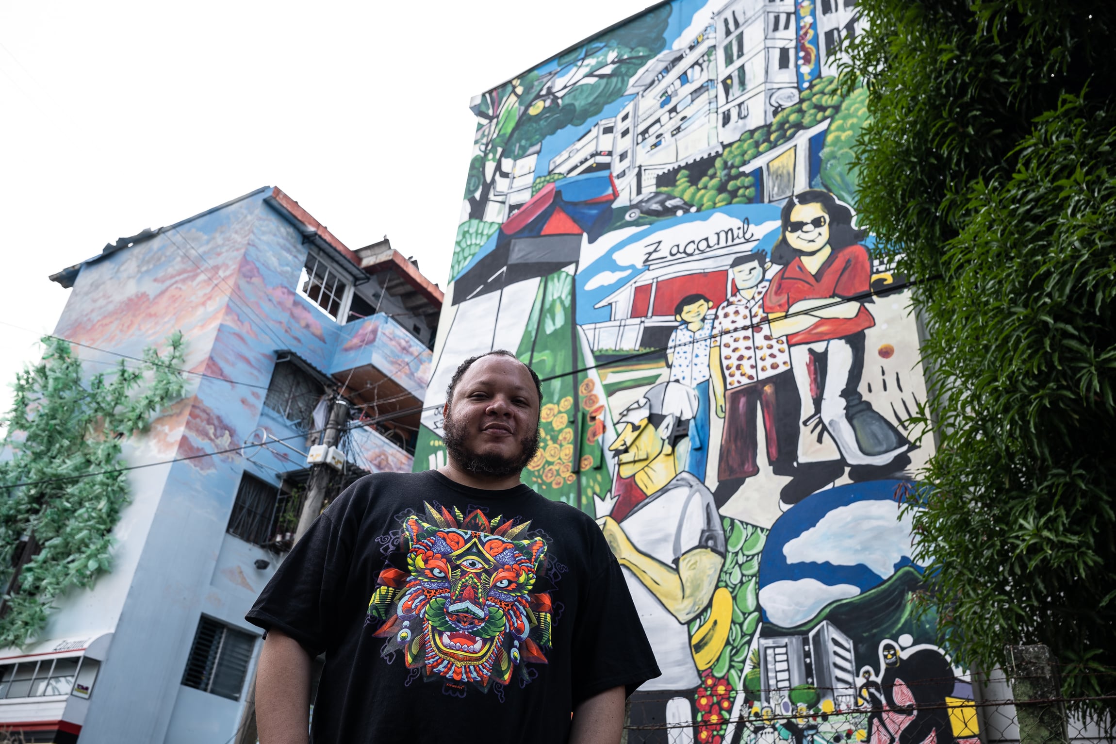 El artista salvadoreño Gerardo Gómez, de 37 años, posa frente a su mural 'Zacamil' en el barrio de Zacamil, que en su día fue uno de los principales bastiones de Barrio 18 Revolucionarios.