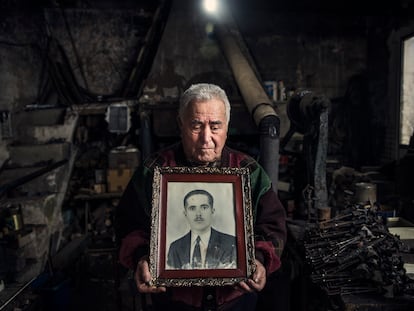 Rafael Gómez Pimpollo Sevilla posa en su fragua en Solana con la foto de su padre, Rafael Gómez-Pimpollo Serrano, asesinado en 1940 cuando él tenía dos años.