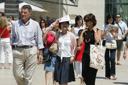 Varios turistas, a la salida del Museo Guggenheim de Bilbao.