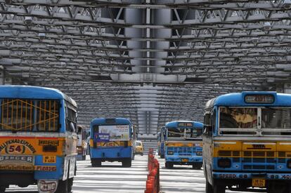 Autobuses públicos cruzan el puente Howrah durante una huelga general en Calcuta (India). 