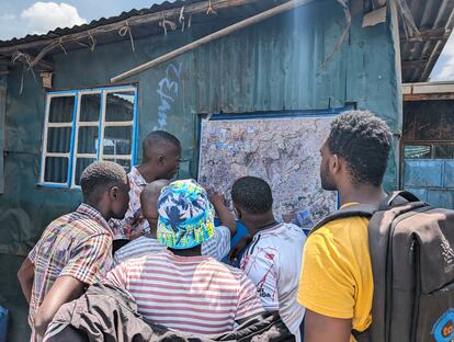 Los voluntarios de Korogocho miran el mapa por el que caminarán con el termómetro para medir la temperatura del aire.