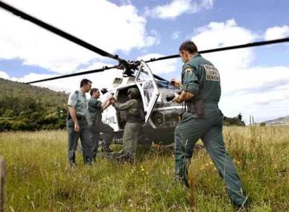 Miembros de la unidad Lume, especializada en investigar incendios, se suben a un helicóptero en Noia para sobrevolar áreas quemadas en agosto.
