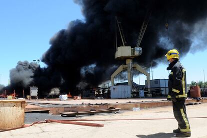 Un bombero, ayer, en las instalaciones de los astilleros de Huelva, donde los trabajadores quemaron un barco, dos talleres y seis contenedores.