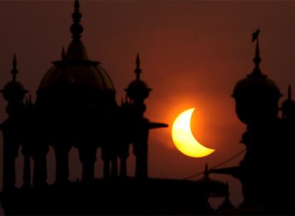 Parece una media Luna, pero es el Sol el que aparece entre las cúpulas del Templo Dorado en la ciudad de Amritsar (India).