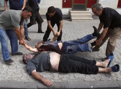 Varias personas recogen los cadáveres de dos hombres muertos durante un bombardeo ruso sobre Gori.