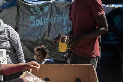 Varios migrantes hacen su turno para merendar: café de olla y pan.