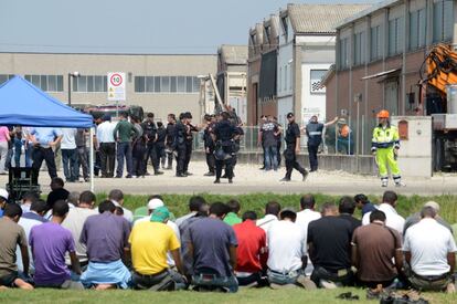 Trabajadores musulmanes rezan a las afueras de una de las fábricas afectadas por el terremoto donde murieron tres operarios.