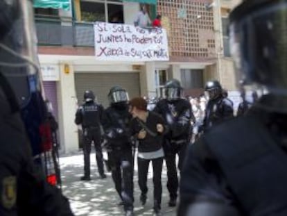 Mossos d'Esquadara detienen a una de las personas que intentaban evitar el deshaucio.