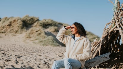 Una chica en la playa con un forro polar.