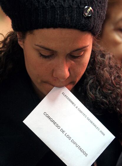 Una joven se dispone a depositar su voto para el Congreso en un colegio de Madrid.