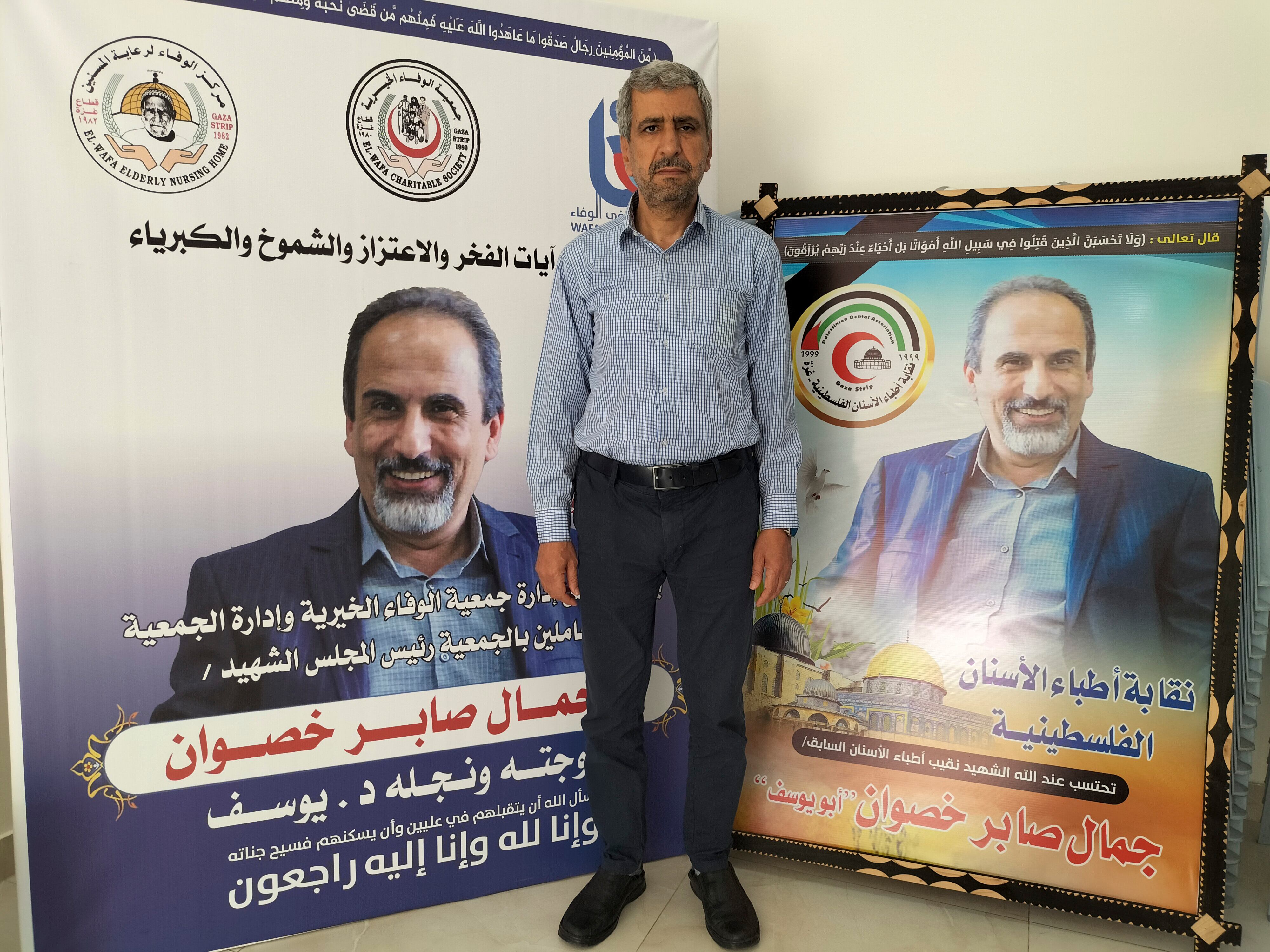 Musa Saber Jasuan, junto a dos imágenes en homenaje a su hermano Yamal, fallecido en los recientes bombardeos israelíes, este lunes en Ciudad de Gaza.