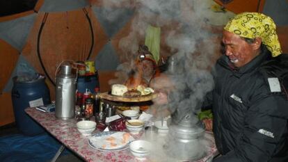 Khesab cocina en el campo base. Al fondo, 'Lolo'