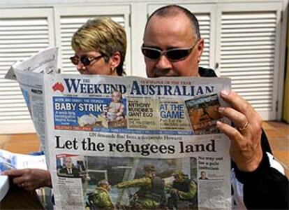 Un ciudadano de Brisbane (Australia) lee un periódico con un  artículo a favor de la entrada de los inmigrantes.