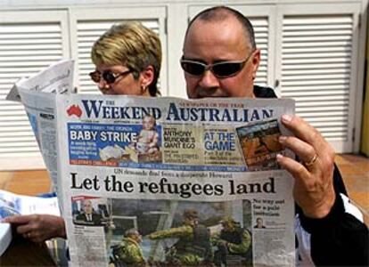 Un ciudadano de Brisbane (Australia) lee un periódico con un artículo a favor de la entrada de los inmigrantes.