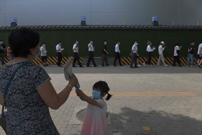 La gente espera en la cola para someterse a la prueba de la covid-19 en una estación de pruebas en Pekín. La capital de China ha levantado parcialmente las restricciones impuestas para evitar una temida segunda ola de infecciones por coronavirus después de que se hayan tomado más de ocho millones de muestras.