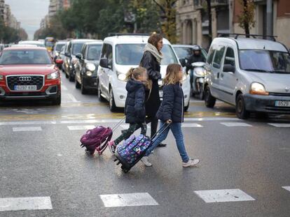 Varias personas cruzan un paso de peatones en la transitada calle Aragó de Barcelona