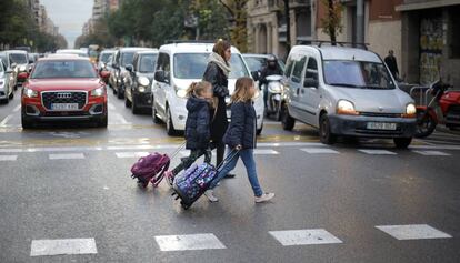 Varias personas cruzan un paso de peatones en la transitada calle Aragó de Barcelona.