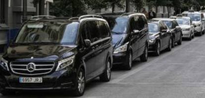 Una fila de vehículos de alquiler con conductor (VTC) y taxis en una calle de Madrid.